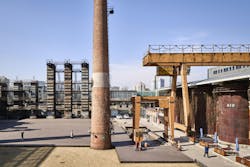 People walking around site with industrial features People walking around site with industrial features