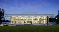 Evening view of a two story academic building light up from within shining out through full glass windows