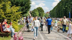 A lot of people walking in a city park on a day off