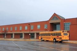 School Building with Bus. Red Brick School Building with Yellow School Bus at the front, ready for transporting students to home or drop off. School Building with Bus. Red Brick School Building with Yellow School Bus at the front, ready for transporting students to home or drop off.